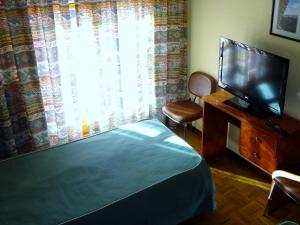 瓜达拉哈拉坎维克酒店的一间卧室设有一张床、一台电视和一个窗口。