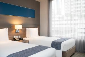 曼谷曼谷沙通智选假日酒店的酒店客房设有两张床和窗户。