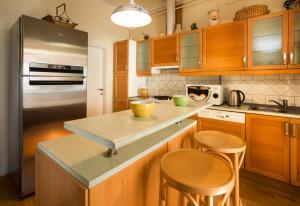 维谢格拉德Honti Apartmanház的厨房配有木制橱柜和不锈钢冰箱。