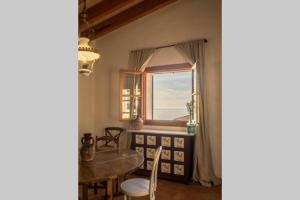 巴尔德莫萨Casa Mistral, Un paraíso de Mar y Montaña的一间带桌子和窗户的用餐室