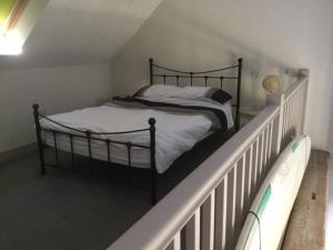 ShorwellSurf Shack - Impeccable 1-Bed Cottage in Shorwell的一间卧室配有一张带白色栏杆的床