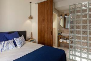德拉塞尔瓦港Playa Vista Mar Duplex的一间卧室设有蓝色的床和玻璃墙