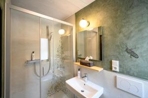 加尔米施-帕滕基兴巴伐利亚生态酒店的浴室配有水槽和带淋浴的淋浴。