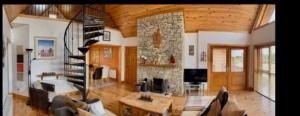 巴利纳莫尔Drumcoura Dreamescape的一间带石头壁炉和螺旋楼梯的客厅