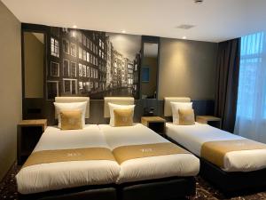 阿姆斯特丹XO Hotels Infinity的酒店客房设有两张床和窗户。