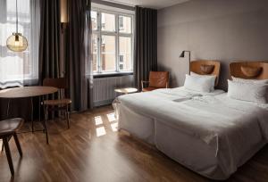 哥本哈根Hotel SP34 by Brøchner Hotels的卧室配有一张白色的大床和一张桌子