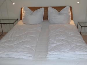 巴特Speicher Residenz Barth E7 App 1的一张带白色床单和枕头的床