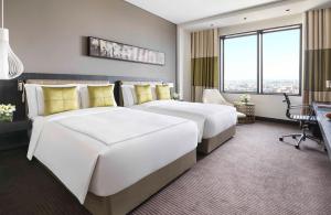利雅德Fairmont Riyadh的酒店客房配有两张床和一张书桌