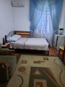 奇姆肯特Hotel ВаYan的一间卧室配有床、沙发和地毯。