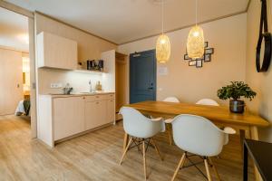 沃索Mere 38 Apartments的厨房以及带木桌和白色椅子的用餐室。