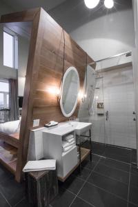 拜圣保罗勒热曼夏荷乐瓦Spa酒店的一间带水槽和镜子的浴室以及一张床