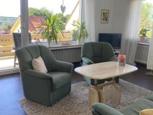 默讷塞Ferienwohnung In den Haargärten的客厅配有两把椅子和一张茶几