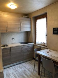 普雷圣迪迪埃Gina CIR PSD0032的厨房配有木制橱柜、桌子和窗户。