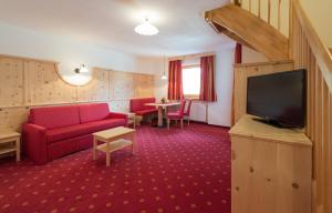 新黎凡特司空瓦尔德活跃酒店的客厅配有红色沙发和平面电视