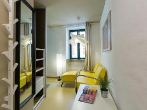 罗维尼Tre Porte Rovinj的客厅配有黄色椅子和桌子