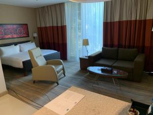 贝鲁特Staybridge Suites Beirut, an IHG Hotel的酒店客房配有床、沙发和桌子。