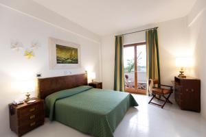 斯卡莱阿玫瑰大酒店的一间卧室设有一张绿色的床和一个窗户。