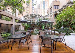 圣保罗因斯坦普拉查国际酒店的一个带桌椅和遮阳伞的庭院