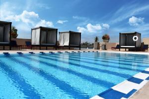 提华纳蒂华纳大酒店的一座带椅子的大型游泳池和一座建筑