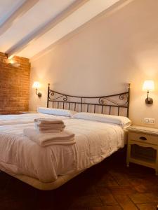 扎弗拉格兰德广场酒店的一间卧室配有一张带两盏灯的大型白色床。
