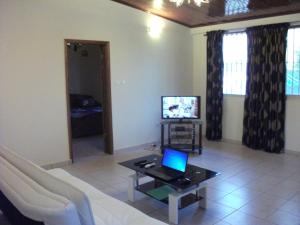 杜阿拉Residence Japoma的带沙发和笔记本电脑桌的客厅