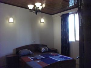 杜阿拉Residence Japoma的一间卧室设有床、窗户和窗户。