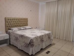 福塔莱萨Casa da Adriana Pousada的一间卧室配有一张带花卉床罩的床