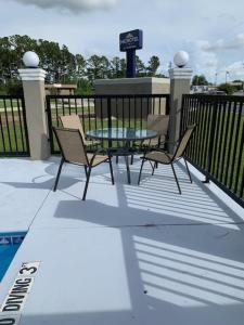 杰克逊维尔Microtel Inn & Suites by Wyndham Camp Lejeune/Jacksonville的一个带桌椅和围栏的庭院