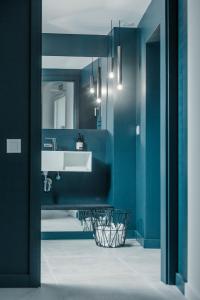 卡达克斯Tramuntana Hotel - Adults Only的浴室设有蓝色的墙壁和白色的盥洗盆。