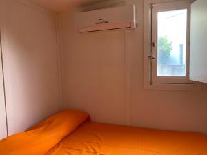 坎波菲利斯·迪·罗切Camping roccella mare的一间小卧室,配有床和窗户
