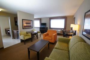坎宁维尔Creekside Hotel & Suites的酒店客房设有一间带沙发和椅子的客厅