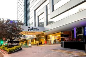 波哥大Radisson Bogota Metrotel的城市建筑物前的商店