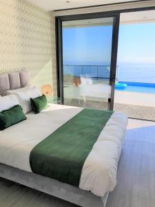 里韦拉布拉瓦Villa Brava Atlântico的一间卧室设有一张大床,享有海景