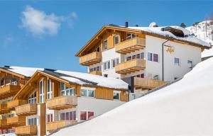 上陶恩Fewo-Obertauern-Steinadler的一座带木阳台的雪覆盖的山间建筑