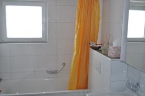 Aeschi bei SpiezRuhe pur的浴室配有橙色淋浴帘和浴缸