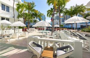 迈阿密海滩AxelBeach Miami South Beach - Adults Only的一个带桌椅和遮阳伞的庭院