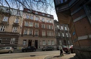 克拉科夫克拉科夫西维奥公寓式酒店的一个人在建筑物前的街道上行走