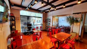 马德普拉塔Hotel Positano的餐厅设有木桌和红色椅子