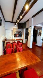 马德普拉塔Hotel Positano的一间会议室,配有木桌和红色椅子