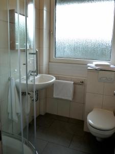 亚琛弗斯特哈斯施塔尔酒店的一间带水槽和卫生间的浴室以及窗户。