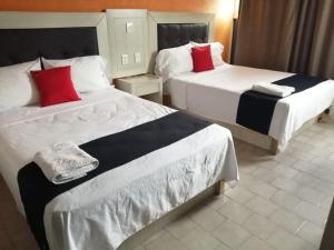 阿瓜斯卡连特斯HOTEL SiCILIA iTALIA的两张位于酒店客房的床铺,配有红色枕头