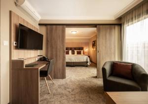 布尔诺EFI SPA Hotel Superior & Pivovar的酒店客房配有一张床、一张书桌和一张沙发。