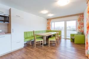 弗拉绍雷特克湖滨公寓酒店的一间带桌子和绿色椅子的用餐室