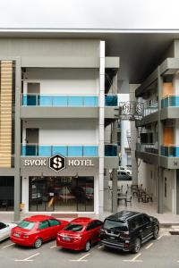 斗湖SVOK Hotel的两辆汽车停在酒店门前的停车场