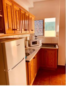 圣尼科拉斯村Apartamento La Real 2的厨房配有白色冰箱和木制橱柜。
