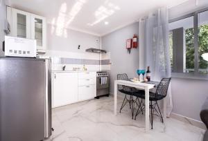 博瓦隆Peponi SelfCatering Apartments的厨房配有桌椅和冰箱。
