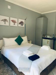 博克斯堡Celtis Lane Guest House的卧室配有带毛巾的大型白色床