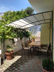 奥瑞比克Spacious garden house, Orebić (4+1)的露台配有桌椅和遮阳伞