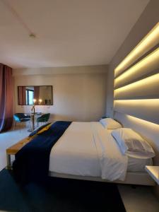 阿韦利诺Grand hotel irpinia & Family SPA的卧室配有一张大白色的床和书桌