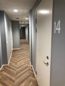 布罗斯Mini-Hotel Borås Regementet的办公室走廊,带门和木地板